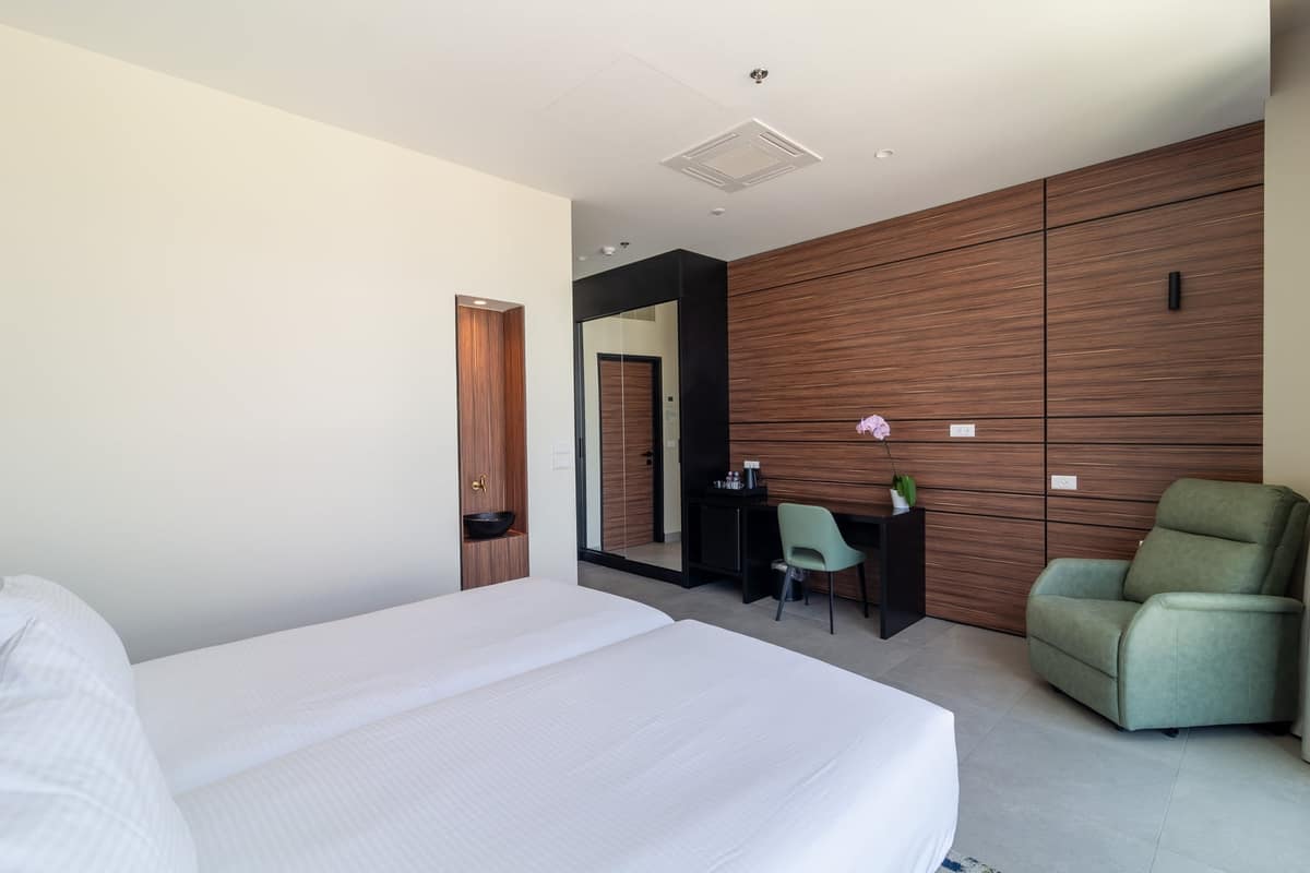 Twin-bed family room with sitting chair at Hotel Yirmiyahu 33, Romema, Jerusalem